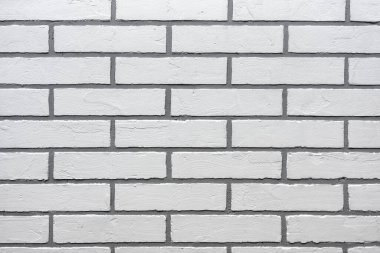 Duvarda beyaz tuğla şeklinde dekoratif alçı var..