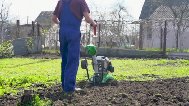 Farmář Zahradě Obdělává Půdu Motorizovaným Kultivátorem Nebo Kormidlem Připravuje Půdu — Stock video