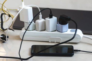 Akıllı telefon, dizüstü bilgisayar, mikrofon gibi birçok şarj aletine bağlı elektrik prizi..