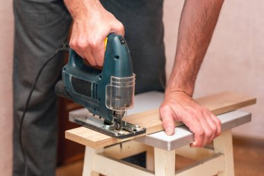 Bir işçi yapbozla tahtayı keser..