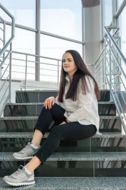 Güzel bir kızın portresi merdivenlerde oturuyor ve bir şeyler düşünüyor..