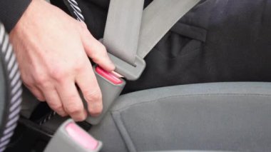 Araba durduktan sonra, erkek sürücü emniyet kemerini çözdü.