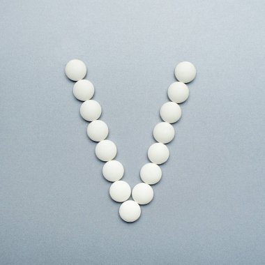 Gri arkaplandaki beyaz haplardan V harfi..