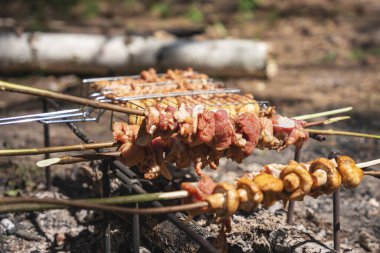 Et şiş kebap ve dallarda mantar yerine kömürde kızartılır..
