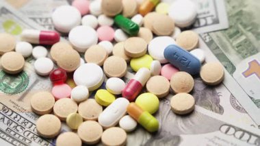 Dolar banknotlarının arka planında haplar ve kapsüller, dairesel rotasyon