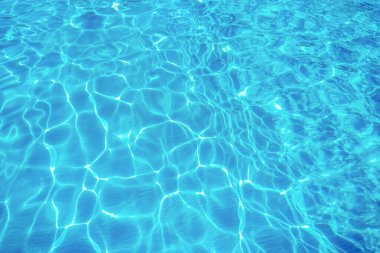 Mavi yüzme havuzunda suyun yüzeyinde dalgalanmalar.
