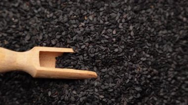 Siyah kimyon tohumları ve ahşap kepçe, doku arka planı