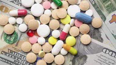 Dolar banknotlarının arka planında haplar ve kapsüller, dairesel rotasyon