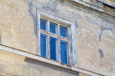 Eski bir binanın duvarını boyayan eski bir ahşap pencere..
