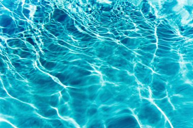 Mavi yüzme havuzunda suyun yüzeyinde dalgalanmalar.