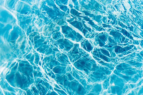Mavi yüzme havuzunda suyun yüzeyinde dalgalanmalar.