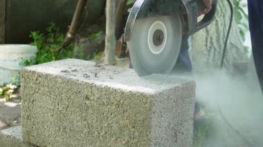 Açı öğütücüyle tuğla kesen işçiler