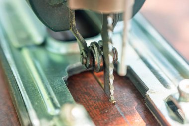 Bir marangoz elektrikli bir yapbozla tahtayı keser..