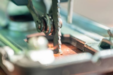 Bir marangoz elektrikli bir yapbozla tahtayı keser..