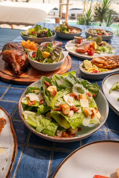 Yüksek açı, kıtır pastırmalı Sezar salatası ve mavi fayanslı parmesan peyniri.