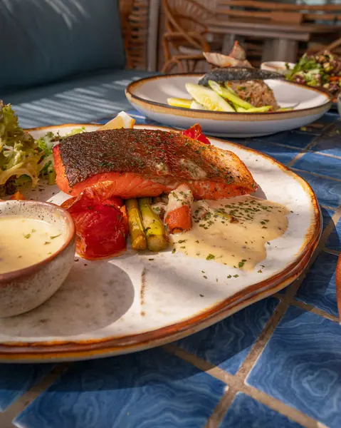 Yaklaş, limon soslu ızgara somon ve mavi fayanslı bahçe salatası.