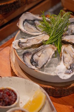 Kapatın, yuvarlak tabakta kızarmış soğan, deniz ürünleri sosu ve biber ezmesi ile birlikte otlar.