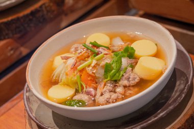 Kurutulmuş mürekkep balığı, kurutulmuş karides, kıymalı domuz eti ve kabın içinde Çin lahanası, ahşap levhanın üzerine yerleştirilmiş. Tayland yemeğinin adı 