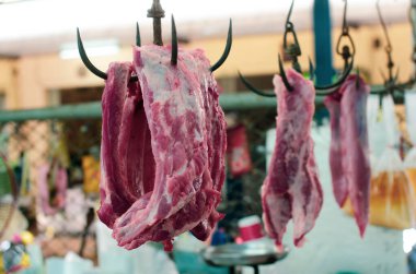 Tayland 'da bir markette kancalardan sarkan çiğ et yakın plan.