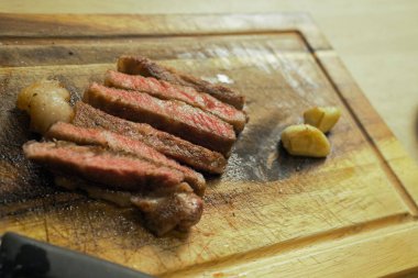 Düzgünce hazırlanmış ızgara biftekle kesme tahtası.