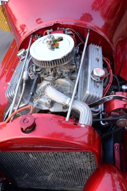 Klasik kırmızı bir arabanın motor kompartımanının yakın görüntüsü, hava filtresi ve emme boruları, vücut metalik gümüş, klasik araba tutkusu ve benzersiz stil ile çelişiyor.