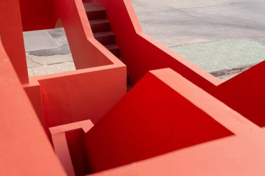 A vibrant red architectural structure, angular walls and a set of stairs leading upwards clipart