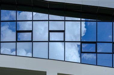 Mavi gökyüzü ve bulutlar modern ofis binası Windows'da yansıyan