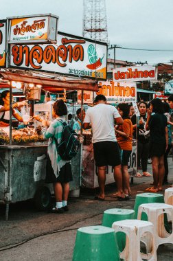 Chon Buri, Thailand - November 27, 2018: People are interacting at the stalls of street food clipart