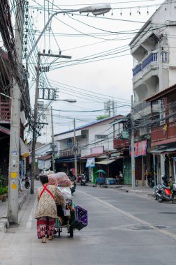 Chon Buri, Tayland - 8 Aralık 2018: Bir şehir bölgesinde sokak manzarası, bir insan bir arabayı yolun aşağısına iter
