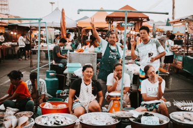 Chon Buri, Thailand - January 11, 2019: A bustling market scene, tables, selling food and containers filled with fish clipart