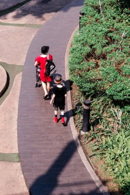 Chon Buri, Tayland - 17 Ocak 2019: Eğri bir yolda yürüyen anne ve çocuk