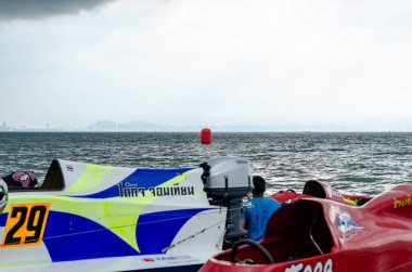 Chon Buri, Tayland - 10 Kasım 2018 Bangsaen Tekne Yarışı Festivali 2018 'de Bangsaen Sahili sahilinde bir sahne. Suyun üzerinde bulutlu bir gökyüzü olan kırmızı bir tekne.