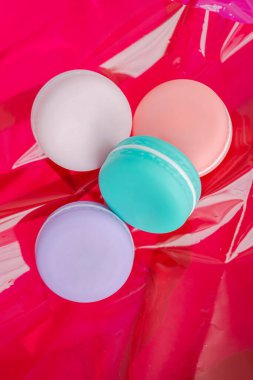 Dört renkli makarna paketleri parlak kırmızı renkte dizilmiştir.