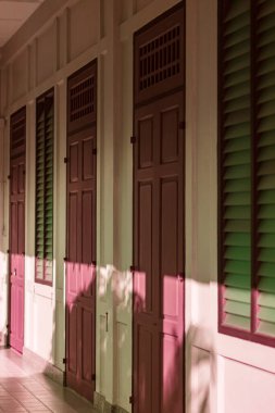 Kızılötesi fotoğrafçılık, aynı kestane rengi kapılar ve yeşil camlarla kaplı güneşli bir koridor koloni tarzı bir binada sakin ve gizemli bir atmosfer yaratıyor.