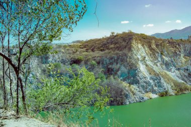 Dik bir uçurum, kayalık ve dengesiz bir araziye sahip doğal bir manzara.