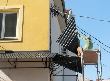 Uzhgorod. Ukrayna. Eylül. 20.09.2022. Binanın giriş kapısının üzerine teneke bir çatı güneşliği yerleştirilmiş.