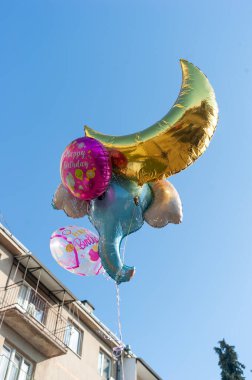 Helyum gazıyla dolu şişme ay, bir fil ve diğer şişme hayvanları mavi gökyüzüne taşıdı.