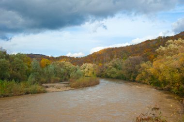 Yağmurdan sonra, Uzh Nehri sonbahar kızıl ormanlarıyla kaplı dağların arasında süzülür..