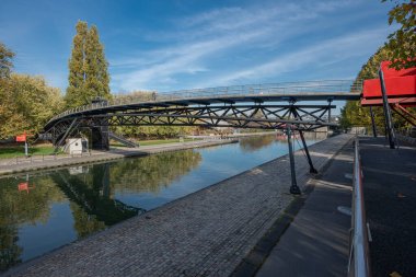 Gündoğumunda modern bir köprünün Ourcq kanalı yansımaları