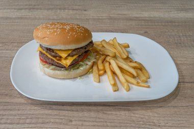 Orta Doğu mutfağı natürmort. Çift peynirli burger, doğranmış biftek ve patates kızartması.