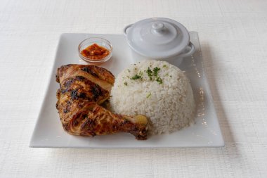 African dishe culinary Still Life. Chicken Yassa with Grilled chicken, rice accompaniement and spicy sauce