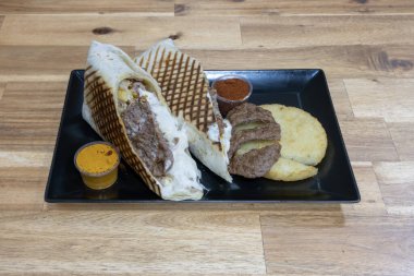 Mexican dishe culinary Still Life. Tacos with meat, fried egg, potatoes pancake, white sauce and spicy sauce