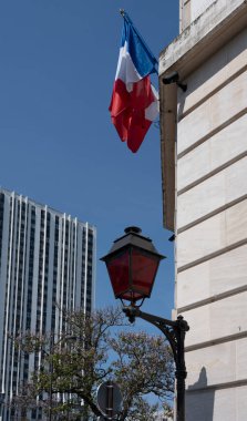 Paris, Fransa - 05: 19: 2023: Taş duvar boyunca bir kırmızı sokak lambası ve bir Fransız bayrağı