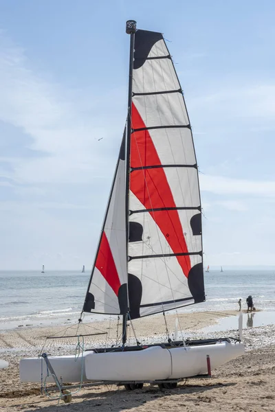 Langrune-Sur-Mer, Fransa - 07: 20 2023: Yelkenli tekneler kumsalda genç insanlarla birlikte duruyor