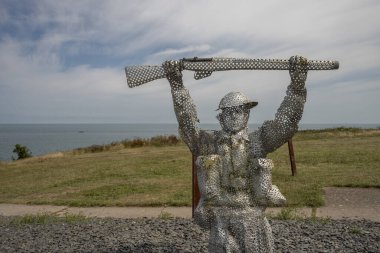 Arromanches-les-Bains, Fransa - 07: 21 2023: Bulutlu ve güneşli bir gökyüzü altında D-day sırasında savaşan ve koşan askerler heykeli