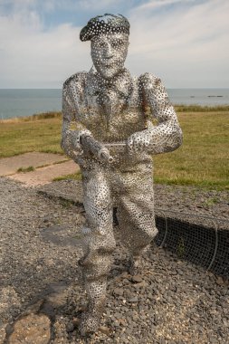 Arromanches-les-Bains, Fransa - 07: 21 2023: Bulutlu ve güneşli bir gökyüzü altında D-day sırasında savaşan ve koşan askerler heykeli