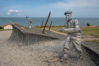 Arromanches-les-Bains, Fransa - 07: 21 2023: Bulutlu ve güneşli bir gökyüzü altında D-day sırasında savaşan ve koşan askerler heykeli