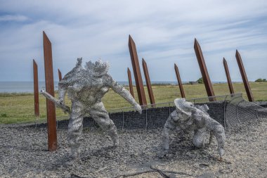 Arromanches-les-Bains, Fransa - 07: 21 2023: Bulutlu ve güneşli bir gökyüzü altında D-day sırasında savaşan ve koşan askerler heykeli