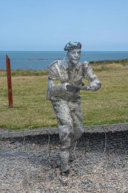Arromanches-les-Bains, Fransa - 07: 21 2023: Bulutlu ve güneşli bir gökyüzü altında D-day sırasında savaşan ve koşan askerler heykeli