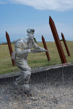 Arromanches-les-Bains, Fransa - 07: 21 2023: Bulutlu ve güneşli bir gökyüzü altında D-day sırasında savaşan ve koşan askerler heykeli
